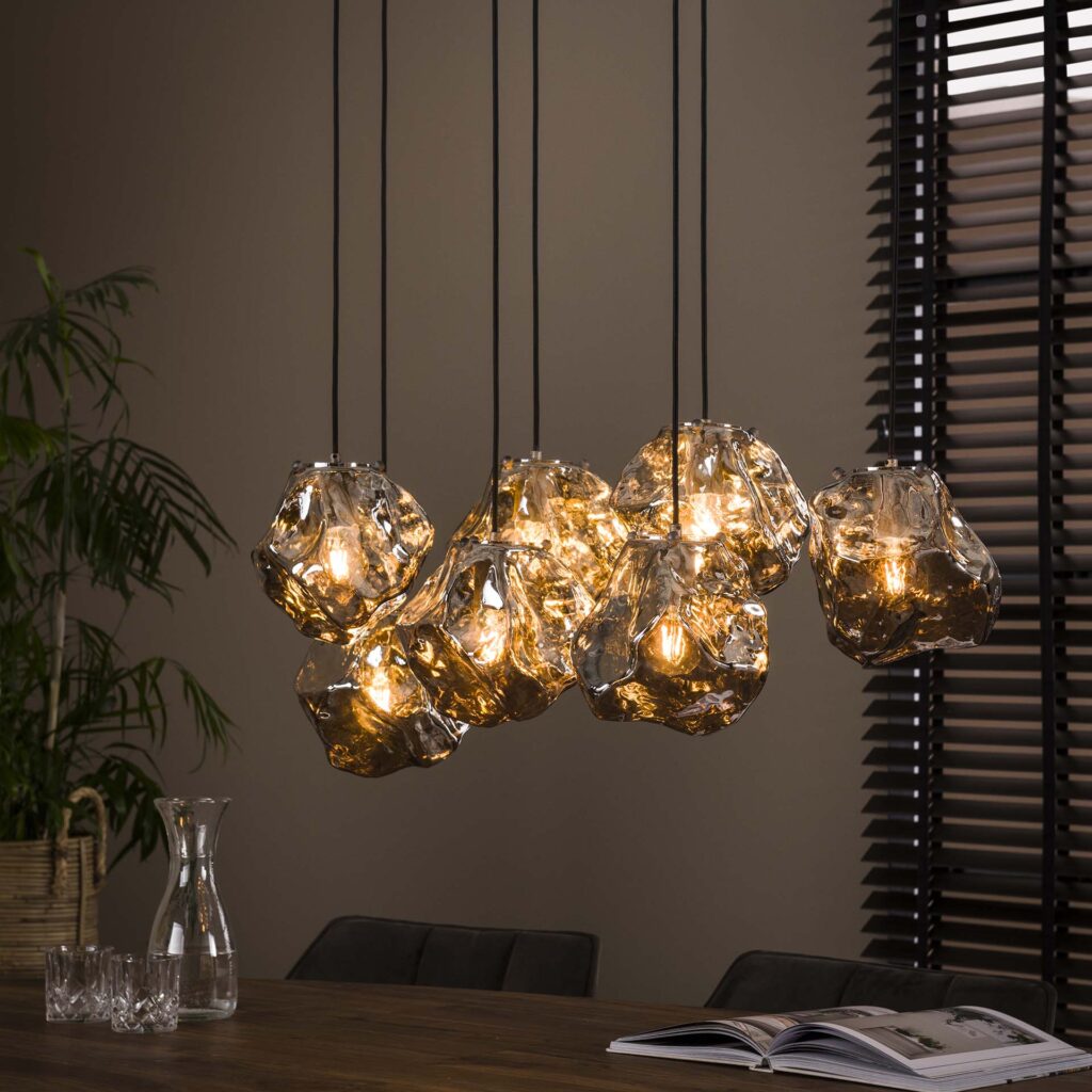moderne hanglamp met gesmolten glas en warme verlichting boven houten tafel in interieur Belga Meubel Brugge