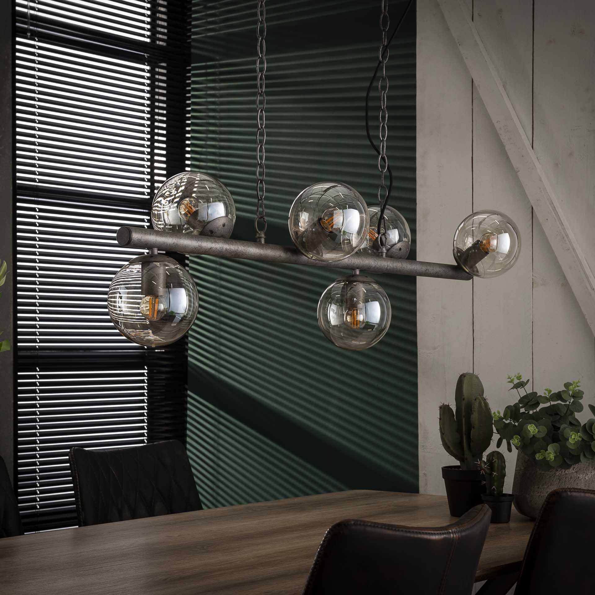 industriële hanglamp met ronde glazen bollen boven houten tafel en zwarte leren stoelen bij Belga Meubel Brugge