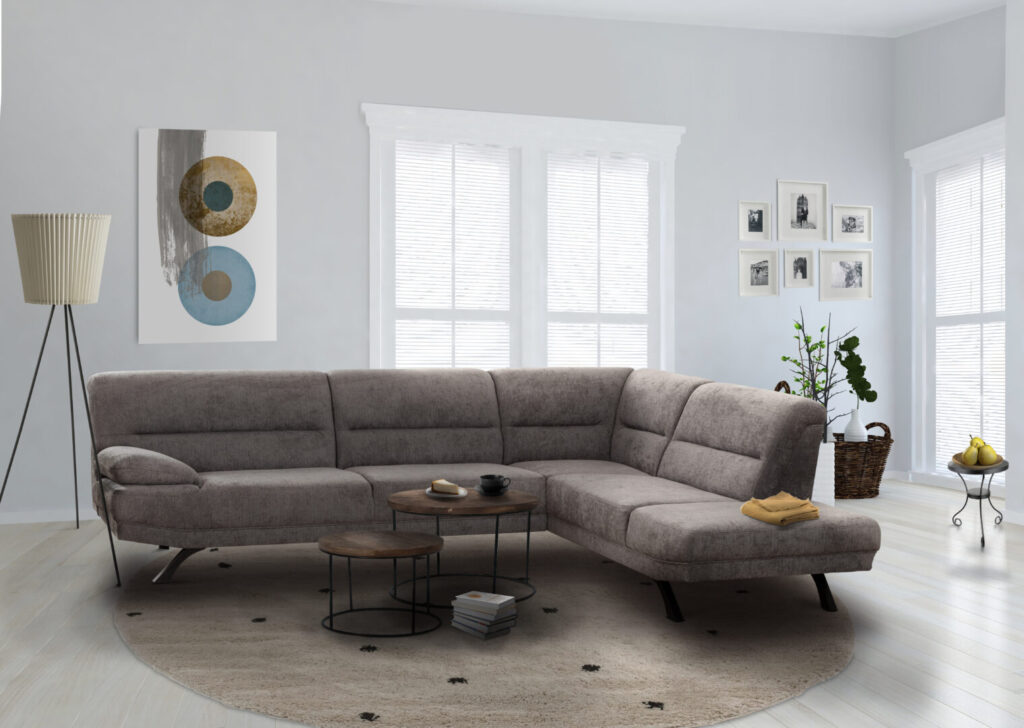 Moderne grijze hoekbank in lichte woonkamer met ronde houten tafels en designlamp, verkrijgbaar bij Belga Meubel Brugge