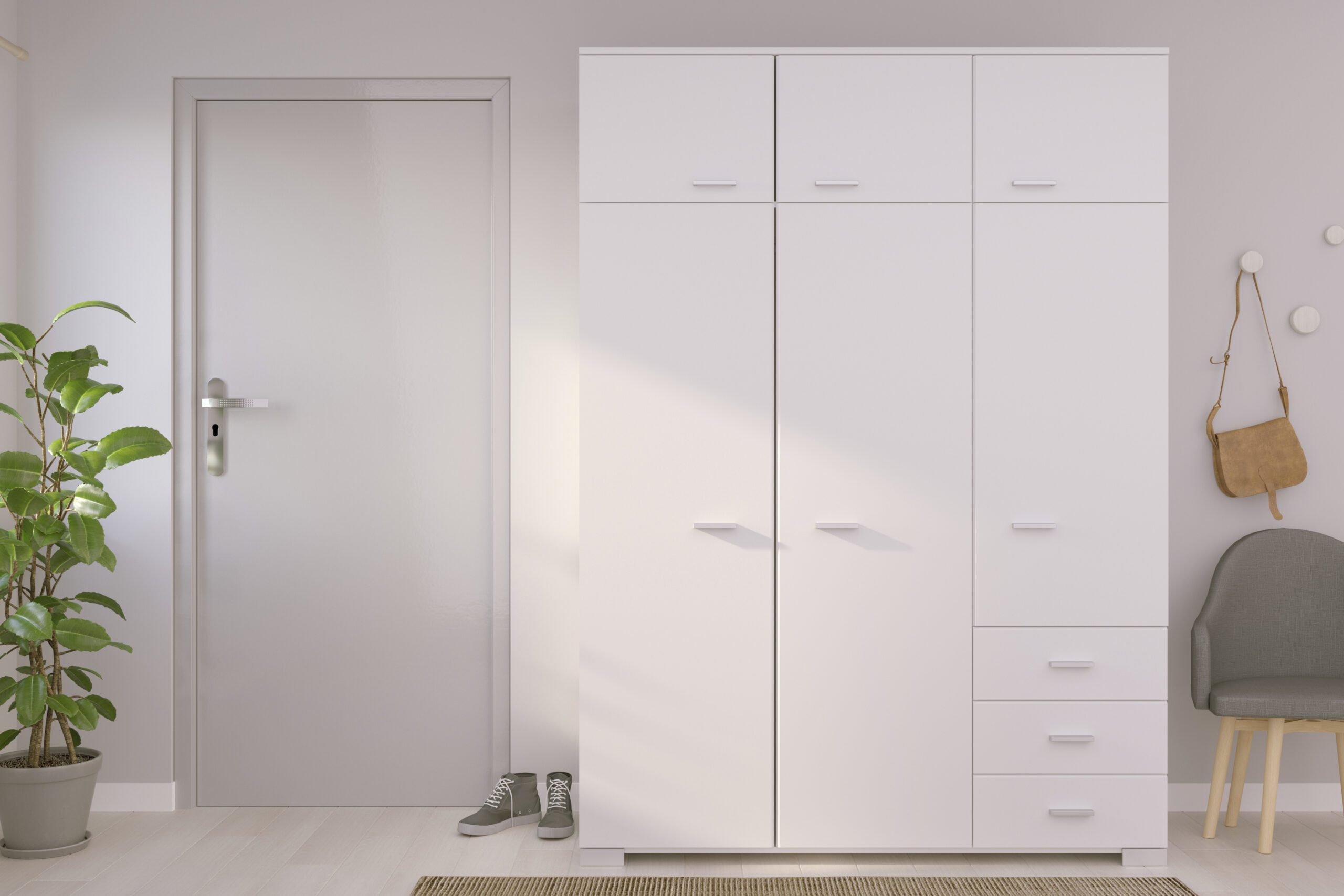 Witte kastmeubel met opbergkasten en laden in moderne hal ingericht met grijze deur plant en stoel Belga Meubel Brugge