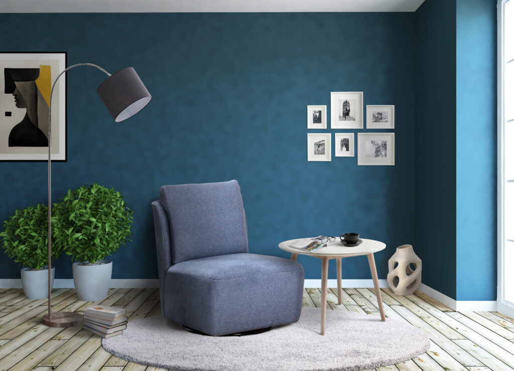 Sfeervolle leeshoek met blauw fauteuil, wit rond tafeltje, planten en wanddecoratie bij Belga Meubel Brugge