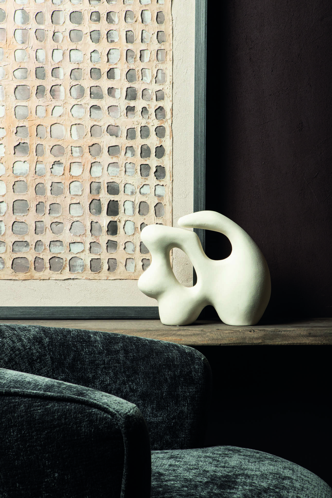 Donkergroen fluwelen fauteuil met abstracte witte decoratieve sculptuur en modern kunstwerk van Belga Meubel