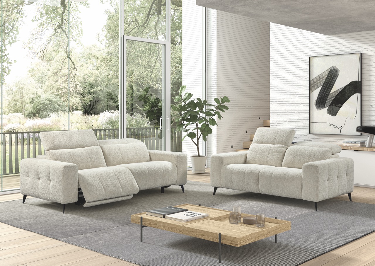 Twee crèmekleurige relaxzetels in een modern interieur met grote ramen en houten vloeren bij Belga Meubel