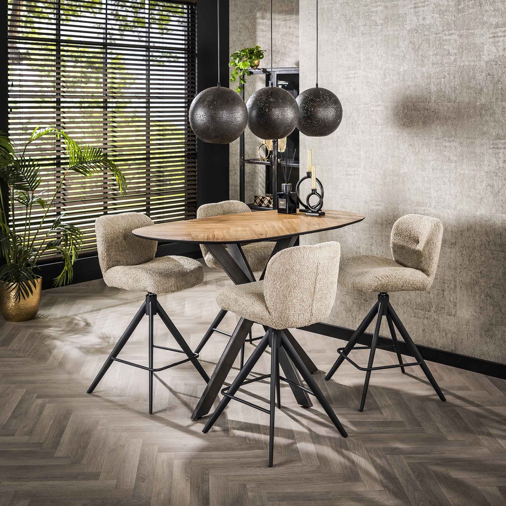 Moderne eettafel met houten blad en vier zachte stoffen stoelen bij raam met houten jaloezieën en drie zwarte hanglampen
