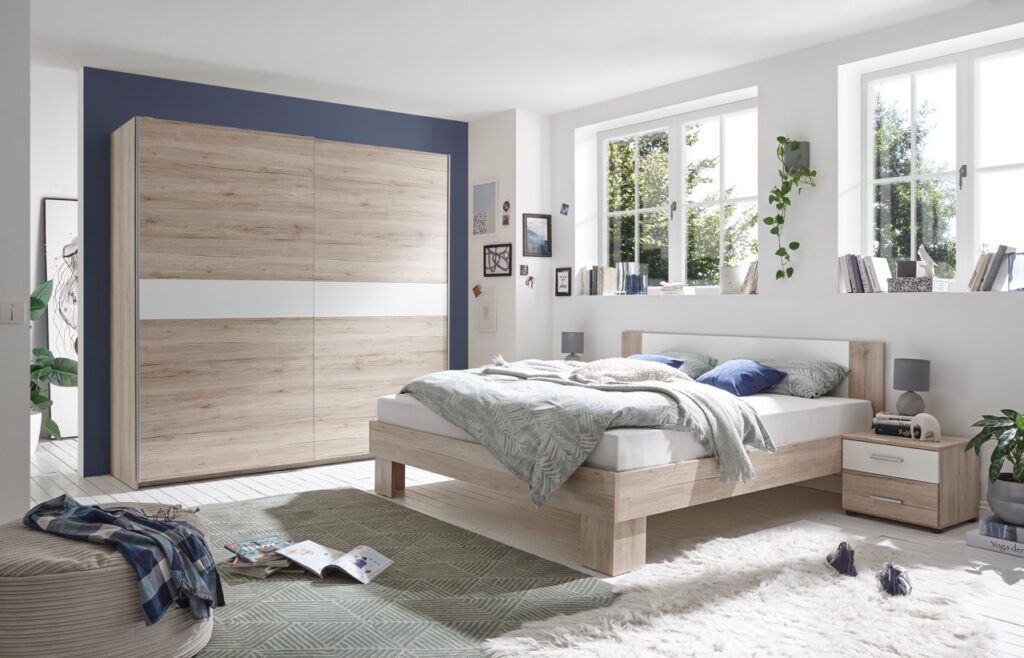 Slaapkamer met licht houten bed, nachtkastje en grote schuifdeurkast bij Belga Meubel Brugge