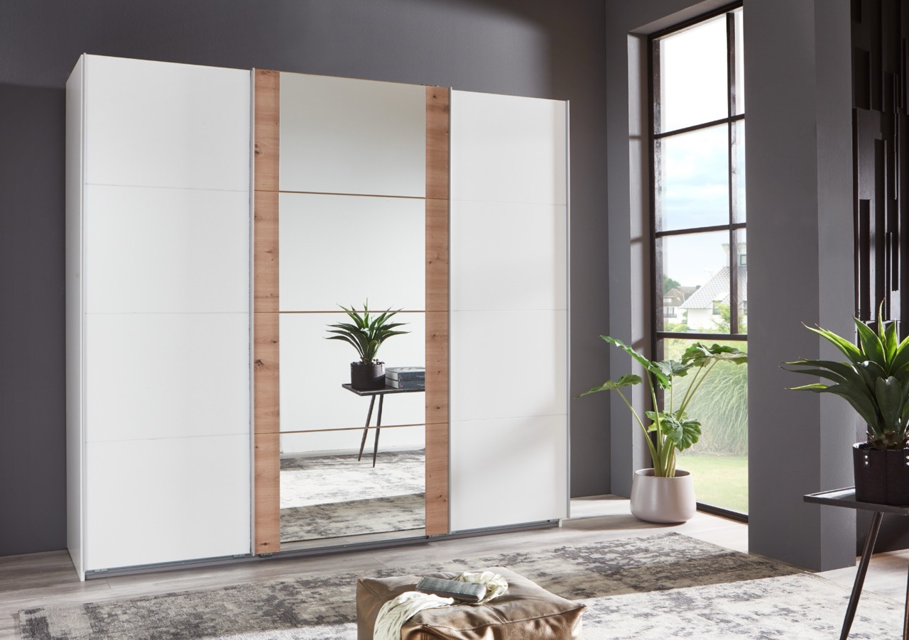 Grote witte schuifdeurkast met spiegel en houten accenten in moderne slaapkamer bij raam met groen planten